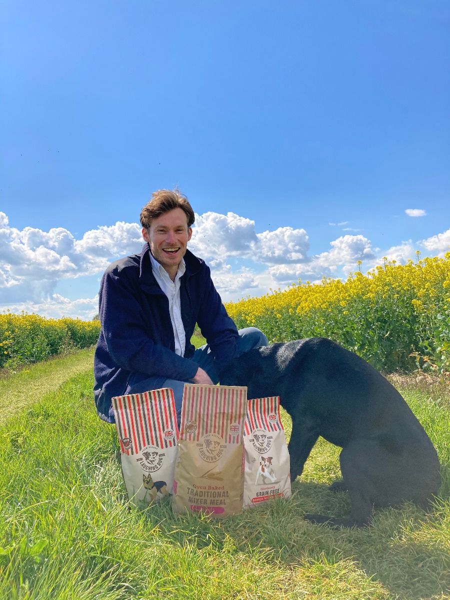 Man with dog and dog food in field | Laughing Dog Food